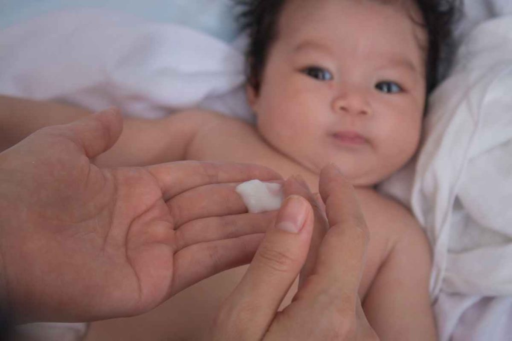 Aplicando loção hidratante para bebê