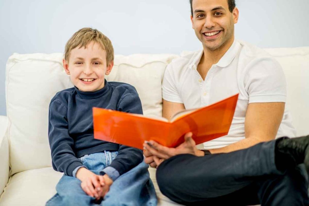 Pai lendo livro para filho autista