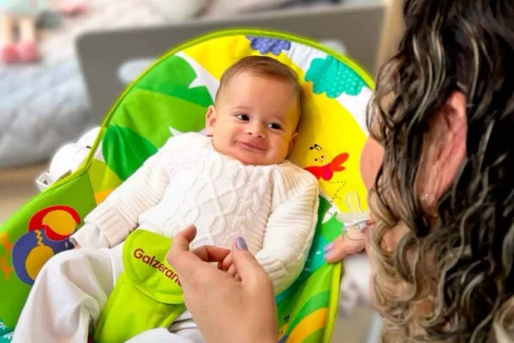 Mãe brincando com seu bebê na cadeira de descanso