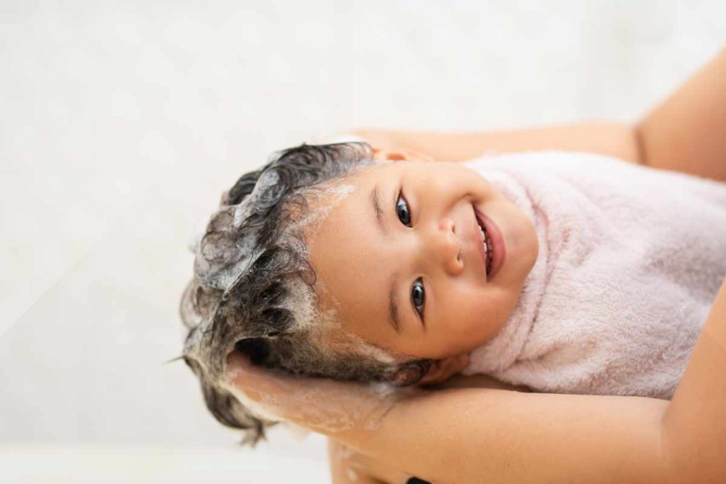 Lavando a cabeça da criança com shampoo