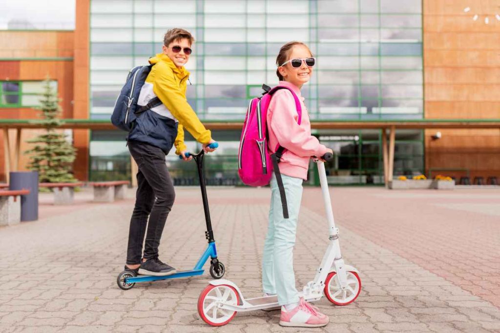 crianças se divertindo com seus patinetes