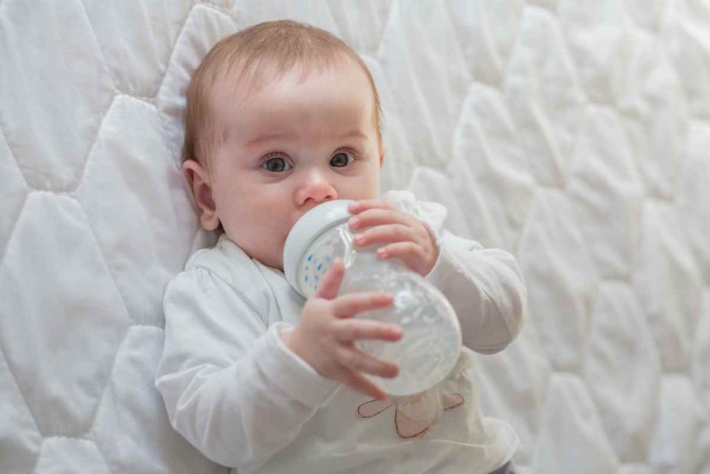 Bebê tomando água na mamadeira