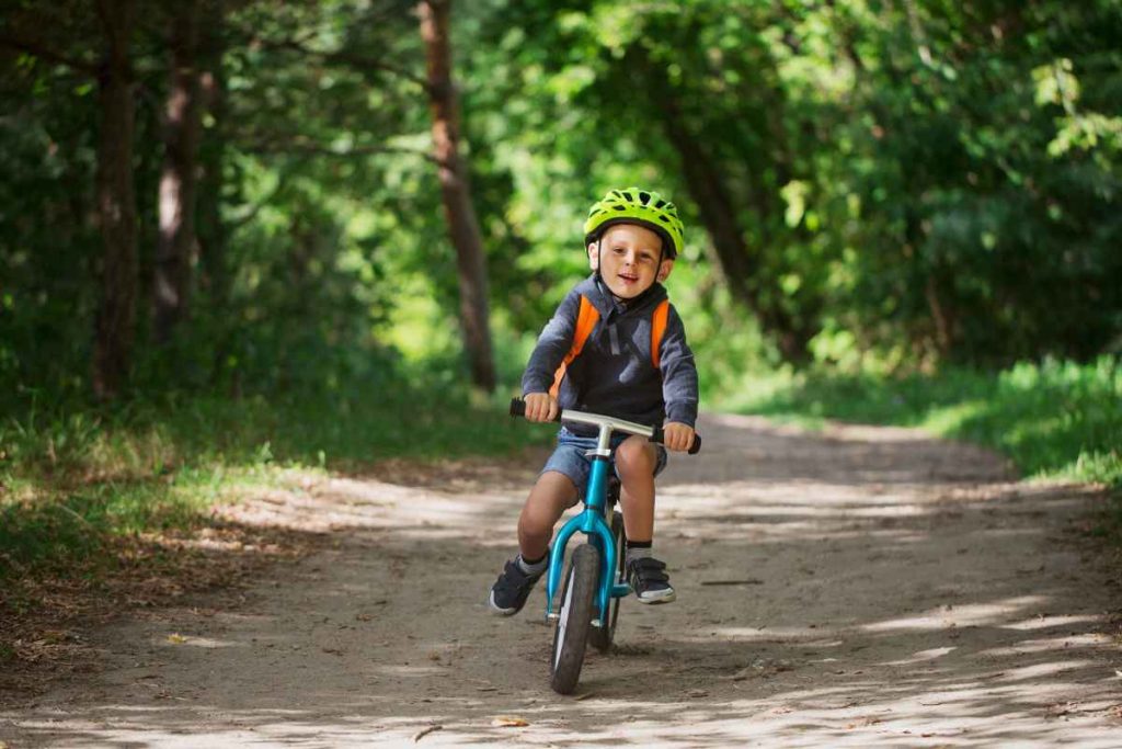 Criança andando de bicicleta de equilíbrio