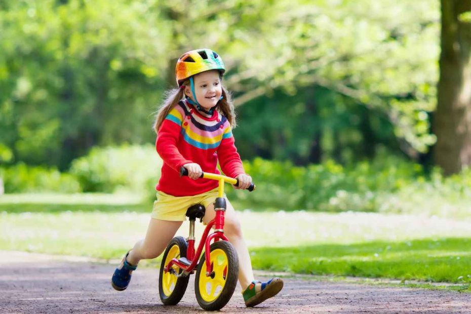 Criança na bicicleta de equilíbrio